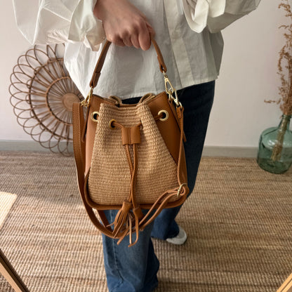 Bolso bucket combinado rafia y piel camel pompón iniciales bordadas