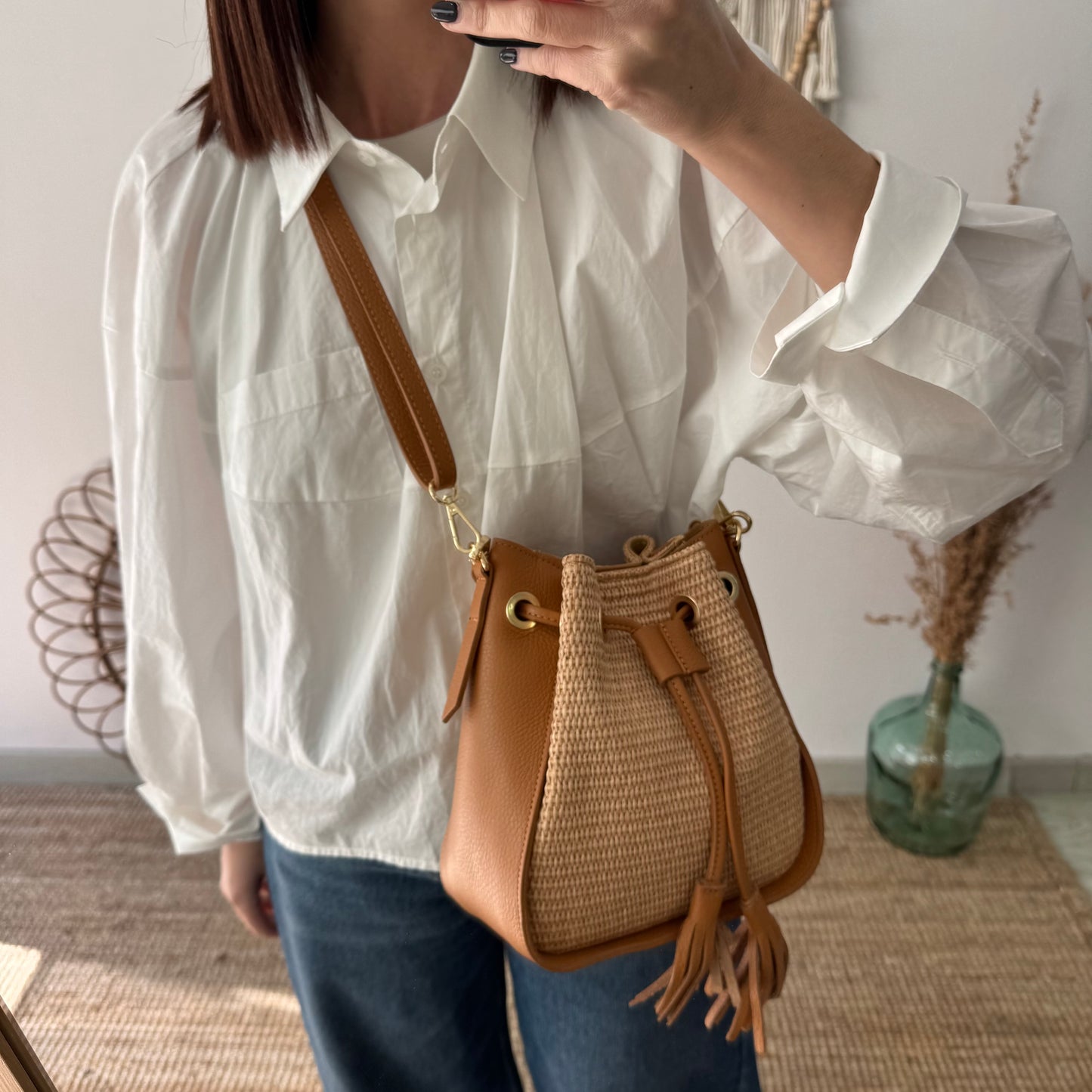 Bolso bucket combinado rafia y piel camel pompón iniciales bordadas