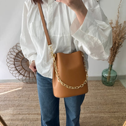 Bolso bucket piel camel cadena dorada iniciales bordadas