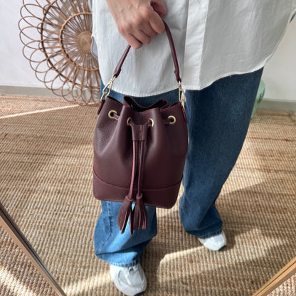 Bolso bucket piel granate pompón iniciales bordadas
