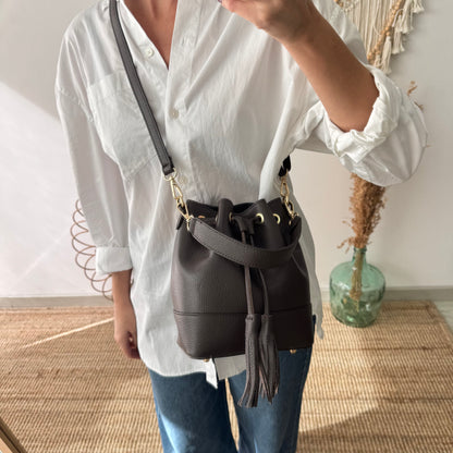 Bolso bucket piel marrón pompón iniciales bordadas