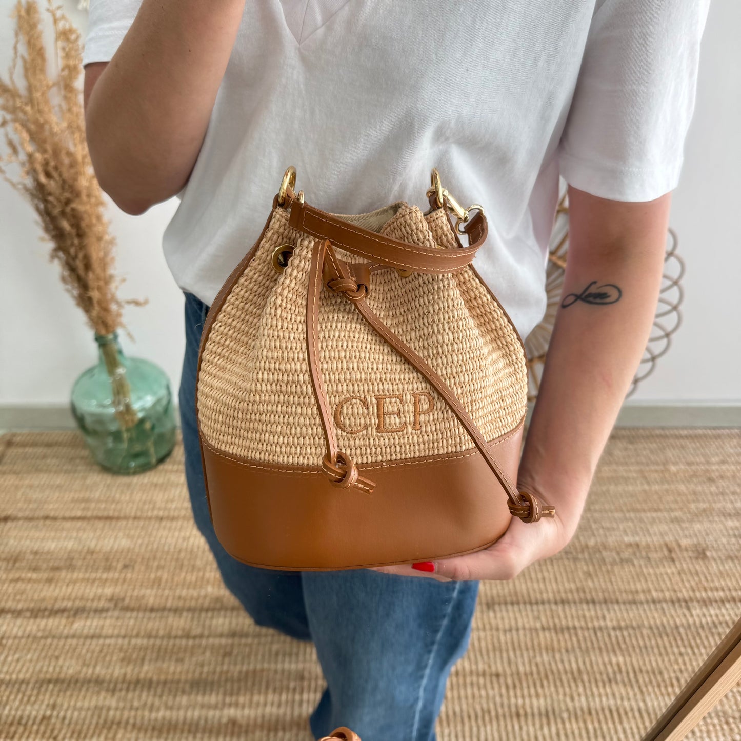 Bolso bucket rafia y piel camel iniciales bordadas