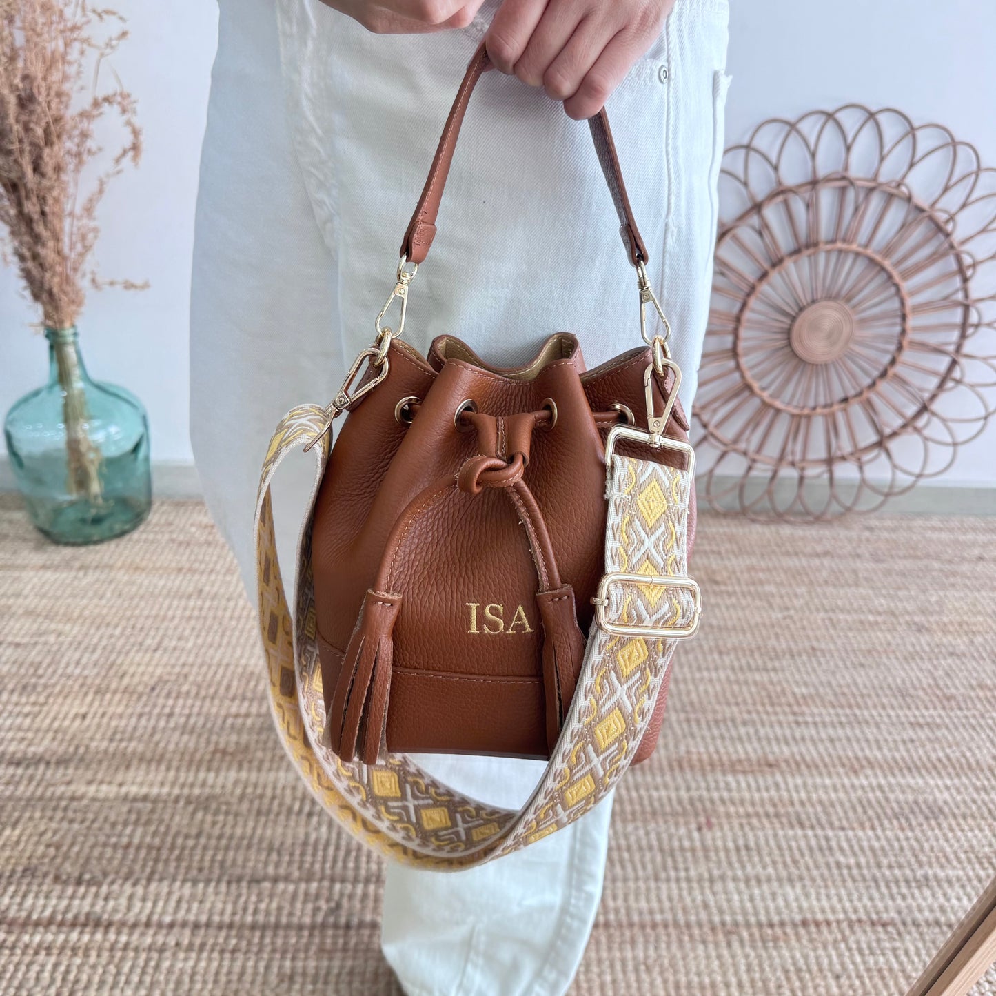 Bolso bucket piel camel pompón iniciales bordadas