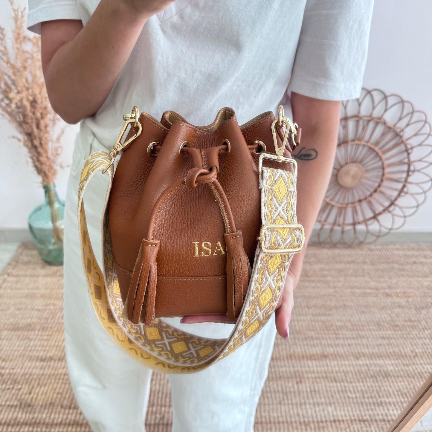 Bolso bucket piel camel pompón iniciales bordadas