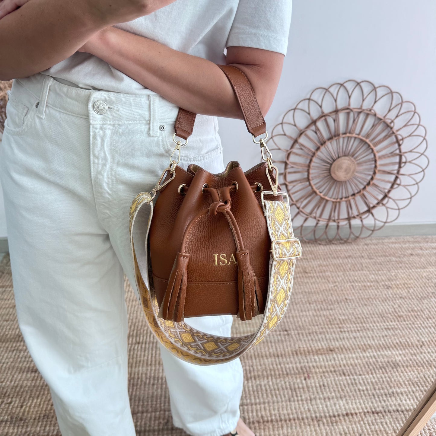 Bolso bucket piel camel pompón iniciales bordadas