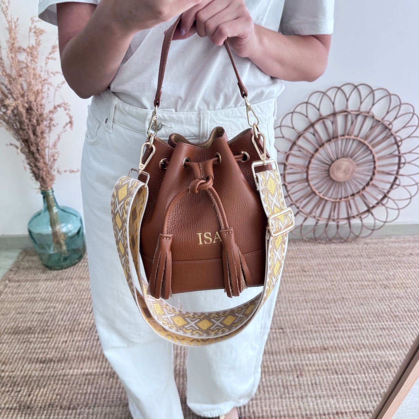 Bolso bucket piel camel pompón iniciales bordadas