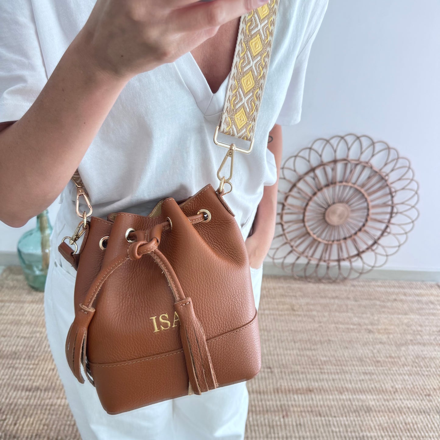 Bolso bucket piel camel pompón iniciales bordadas