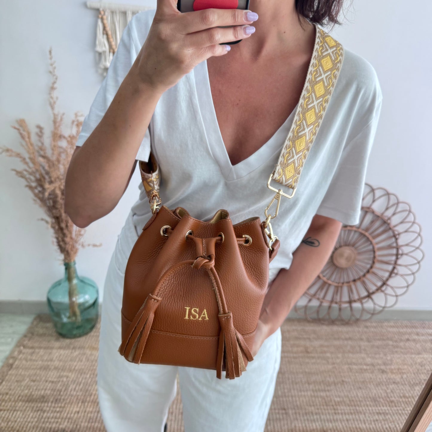 Bolso bucket piel camel pompón iniciales bordadas