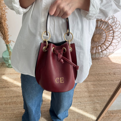 Bombonera piel granate arandelas doradas iniciales bordadas