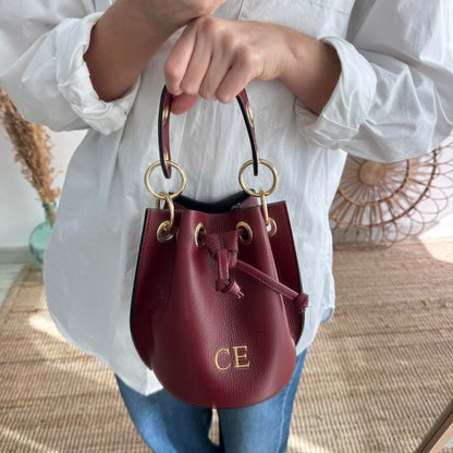 Bombonera piel granate arandelas doradas iniciales bordadas