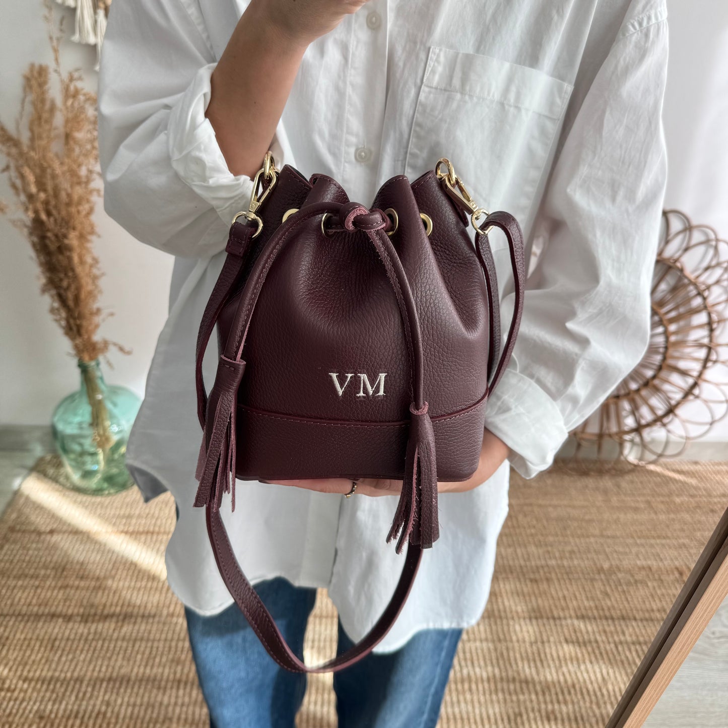 Bolso bucket piel granate pompón iniciales bordadas