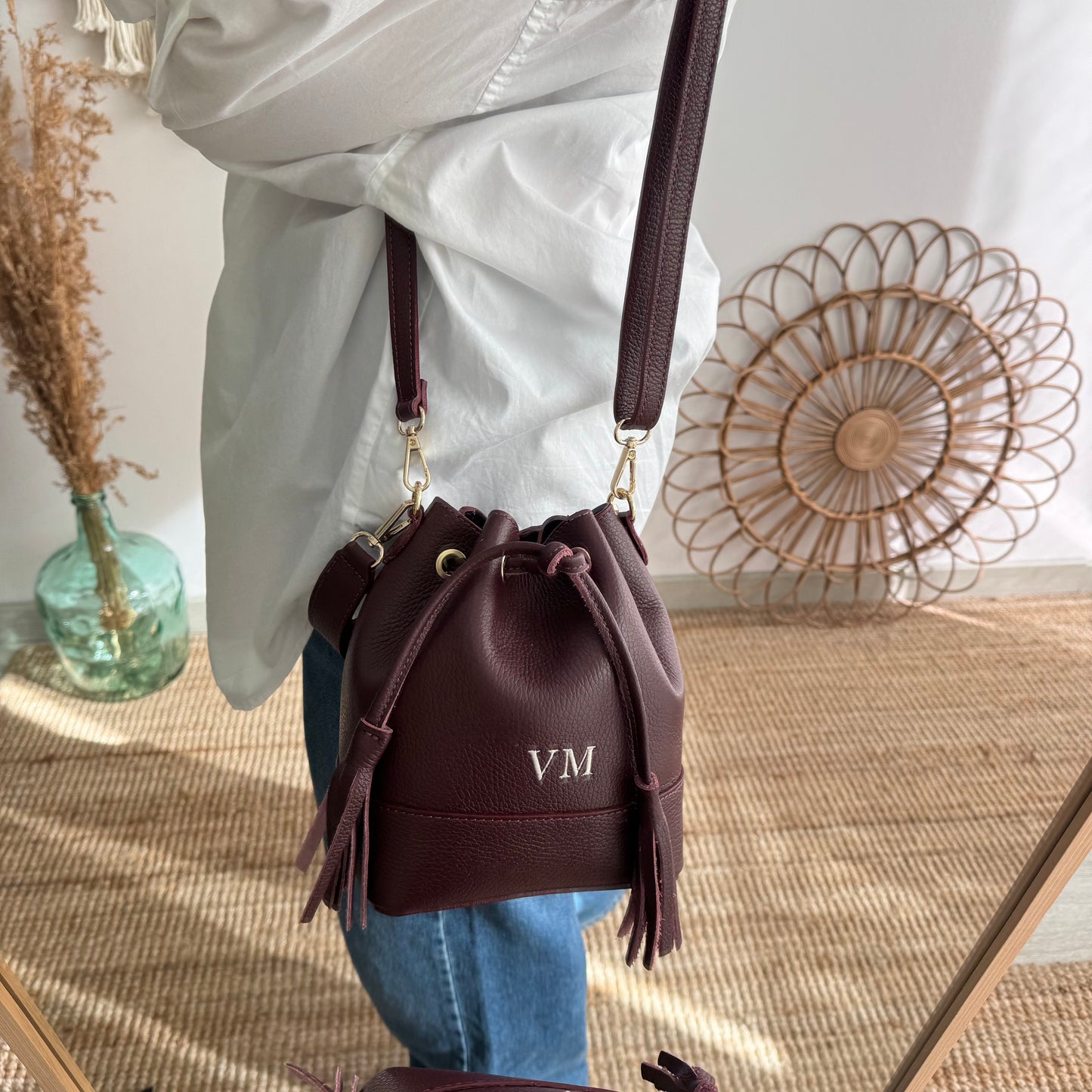 Bolso bucket piel granate pompón iniciales bordadas