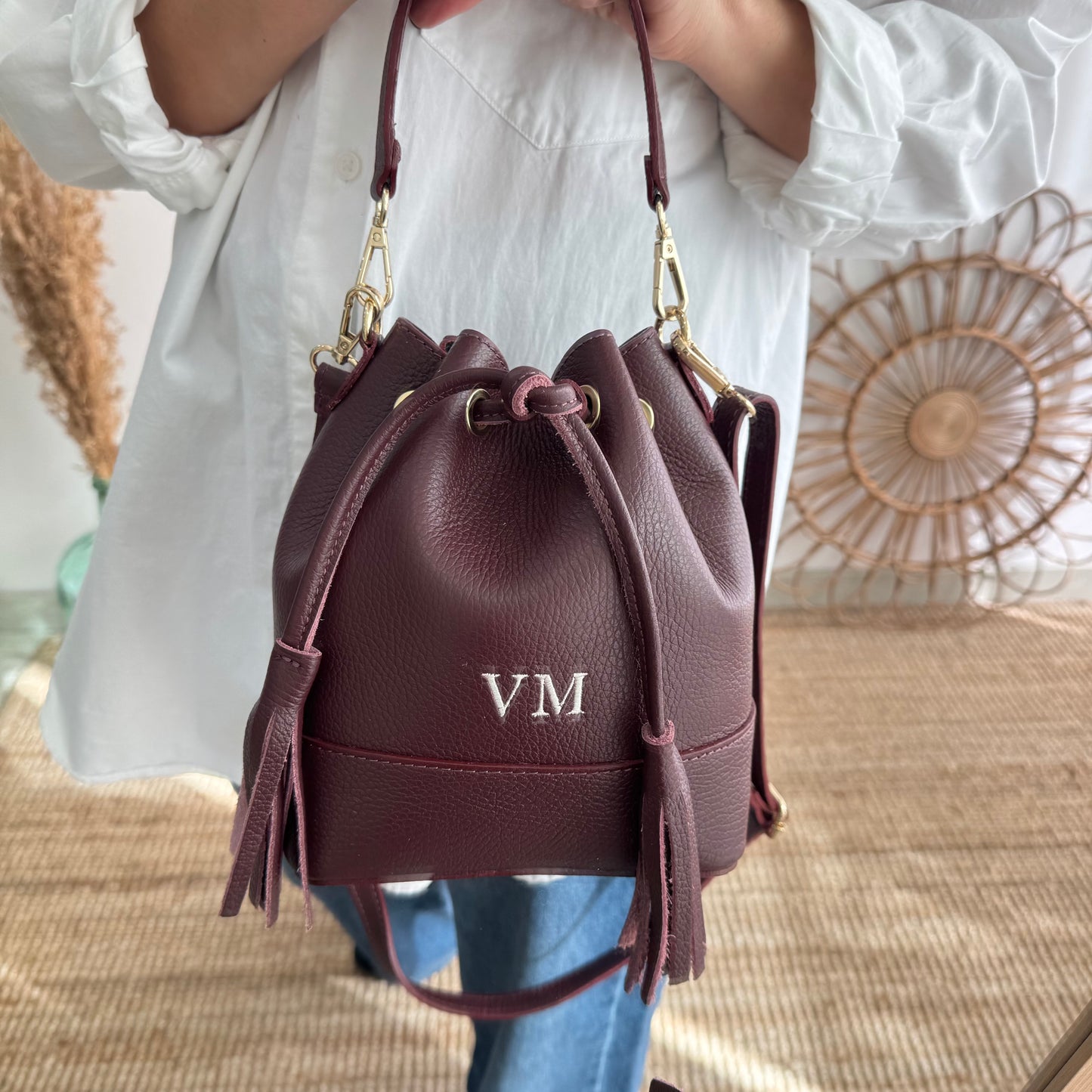 Bolso bucket piel granate pompón iniciales bordadas