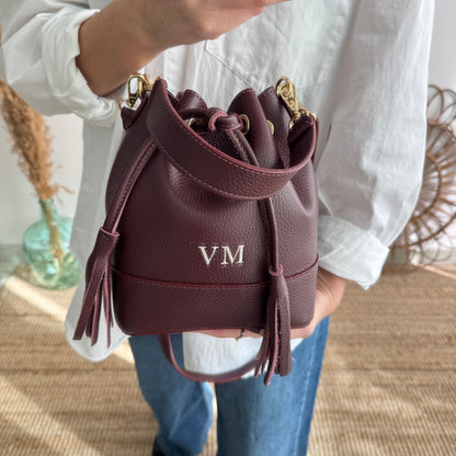 Bolso bucket piel granate pompón iniciales bordadas