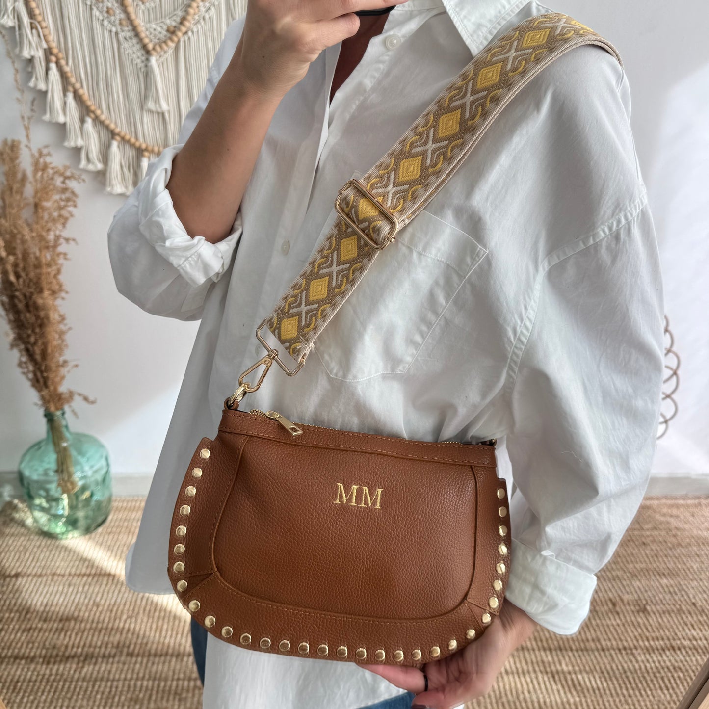 Bandolera ovalada piel tachuelas camel iniciales bordadas