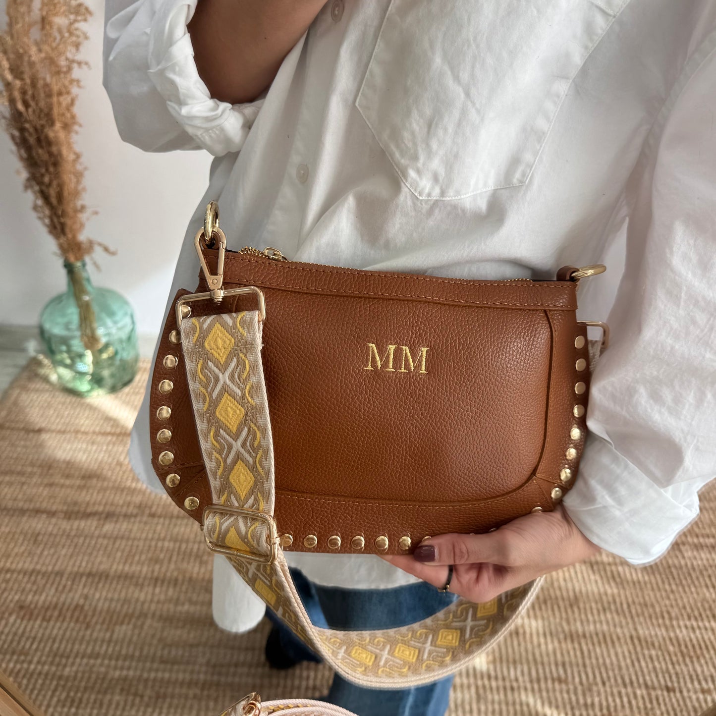 Bandolera ovalada piel tachuelas camel iniciales bordadas