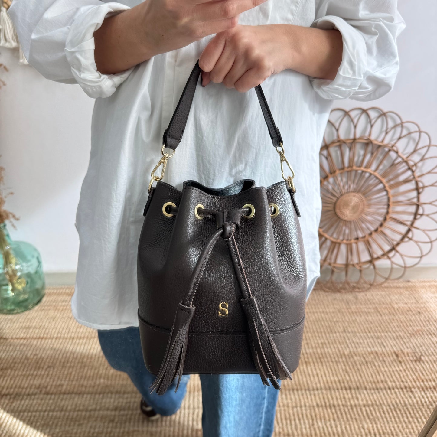 Bolso bucket piel marrón pompón iniciales bordadas