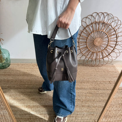 Bolso bucket piel marrón pompón iniciales bordadas