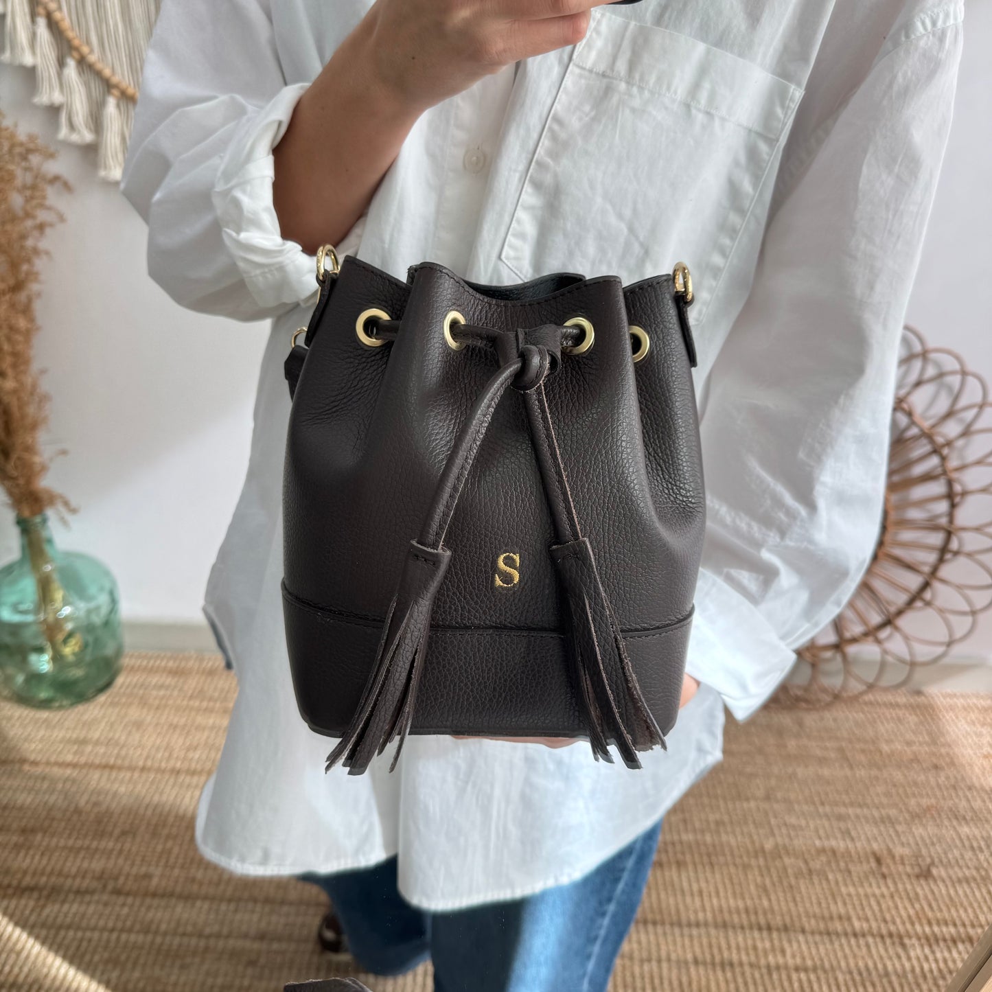 Bolso bucket piel marrón pompón iniciales bordadas