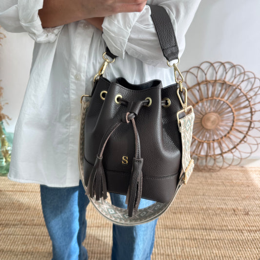 Bolso bucket piel marrón pompón iniciales bordadas