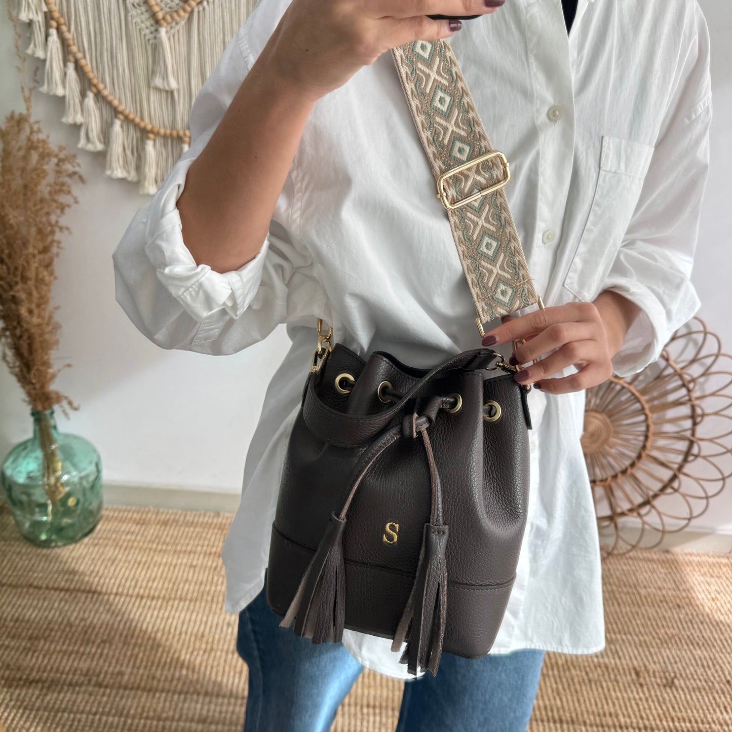 Bolso bucket piel marrón pompón iniciales bordadas