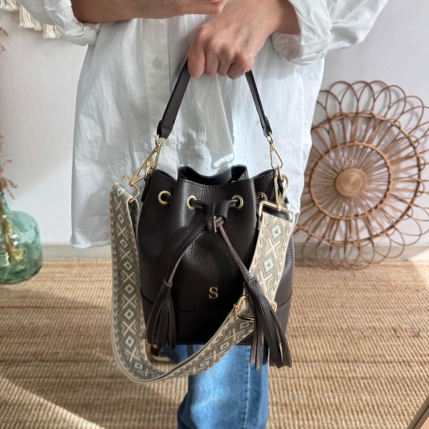 Bolso bucket piel marrón pompón iniciales bordadas