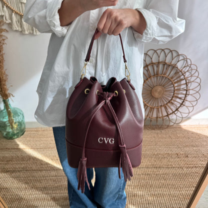 Bolso bucket piel granate grande pompón iniciales bordadas