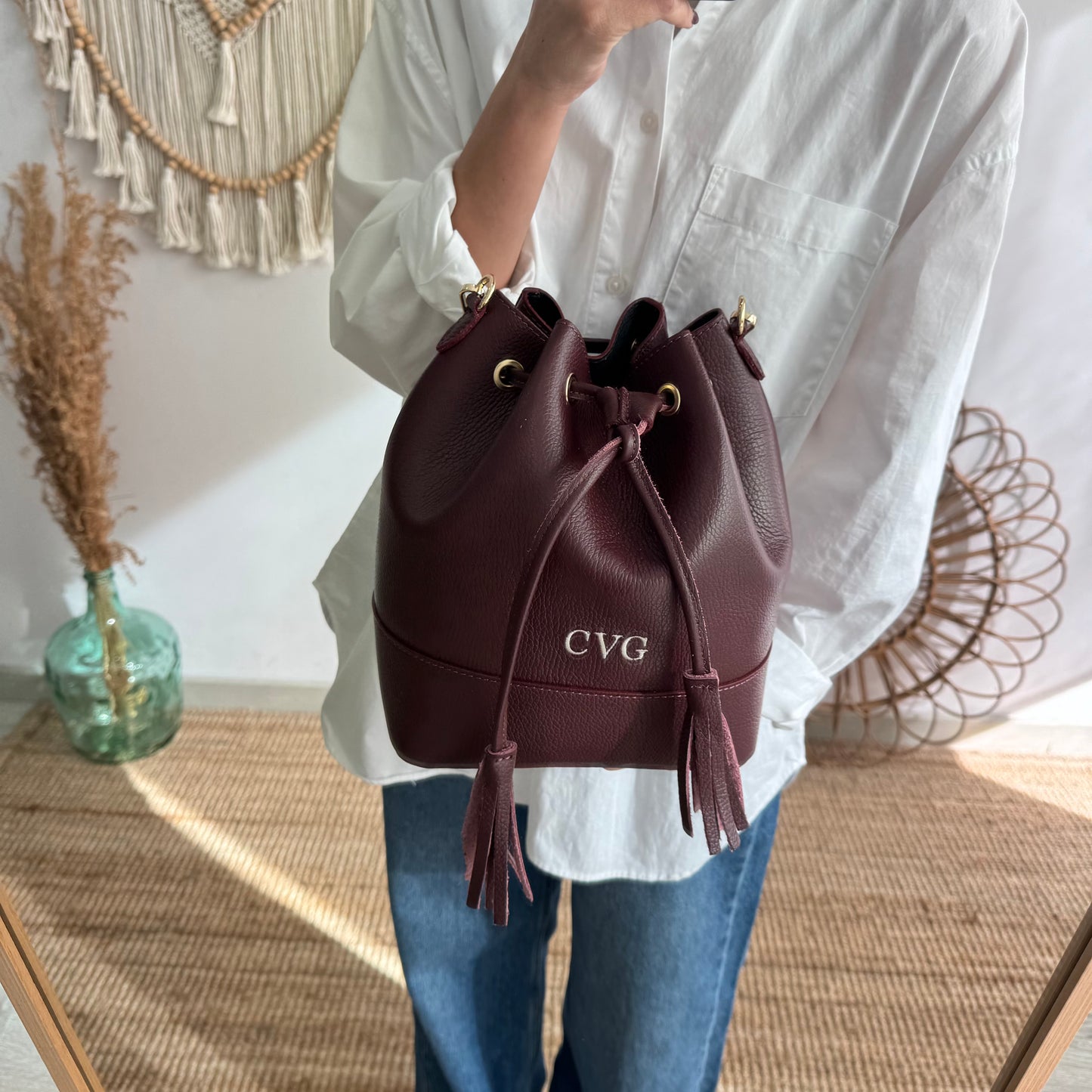 Bolso bucket piel granate grande pompón iniciales bordadas