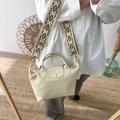 Bolso ovalado piel beige solapa iniciales bordadas