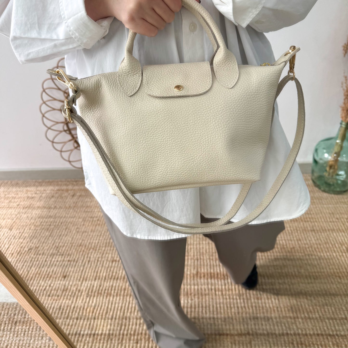 Bolso ovalado piel beige solapa iniciales bordadas