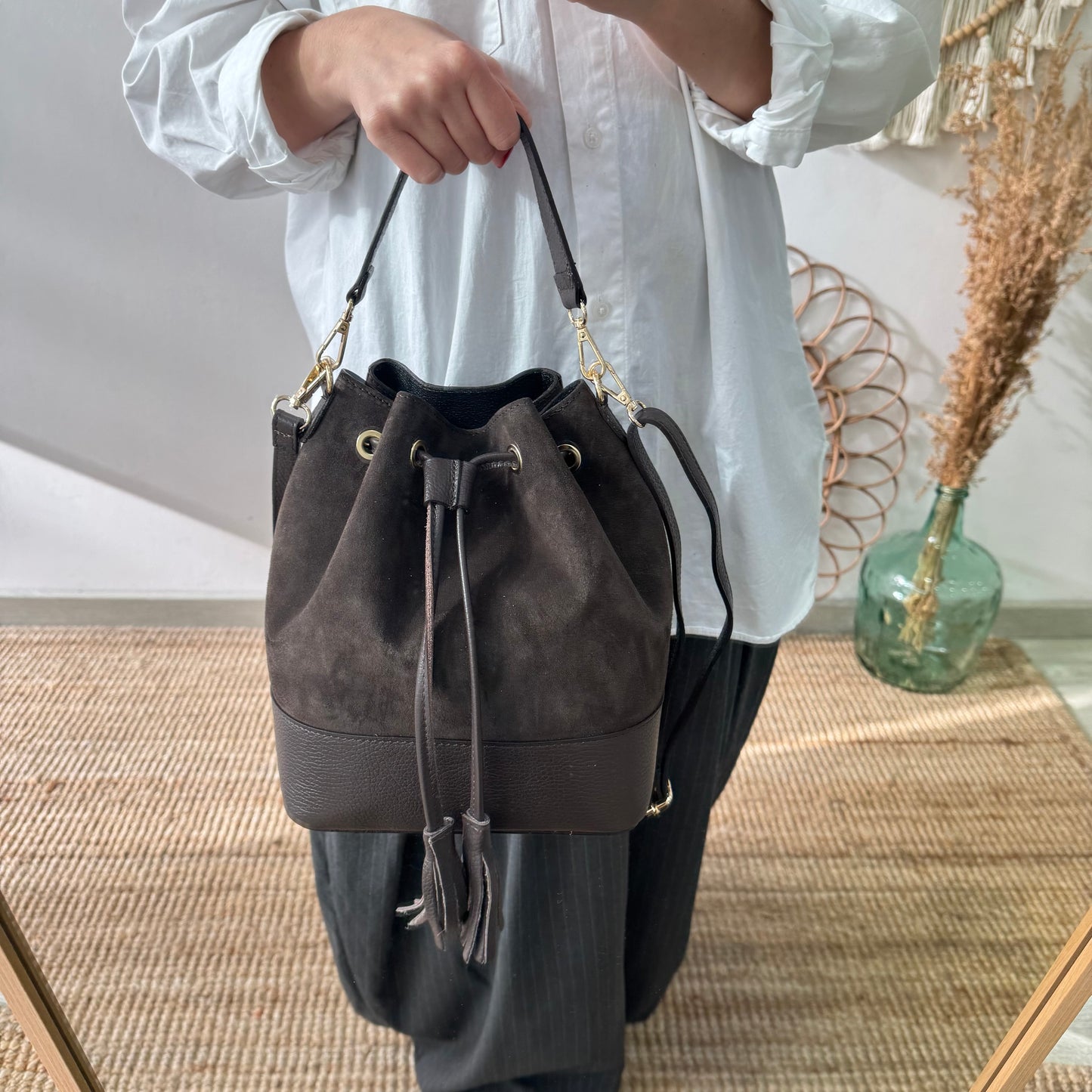 Bolso bucket serraje y piel marrón grande pompón iniciales bordadas