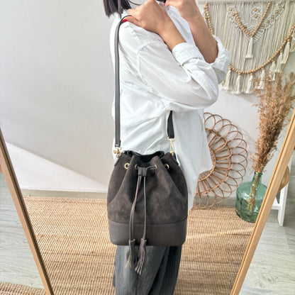 Bolso bucket serraje y piel marrón grande pompón iniciales bordadas