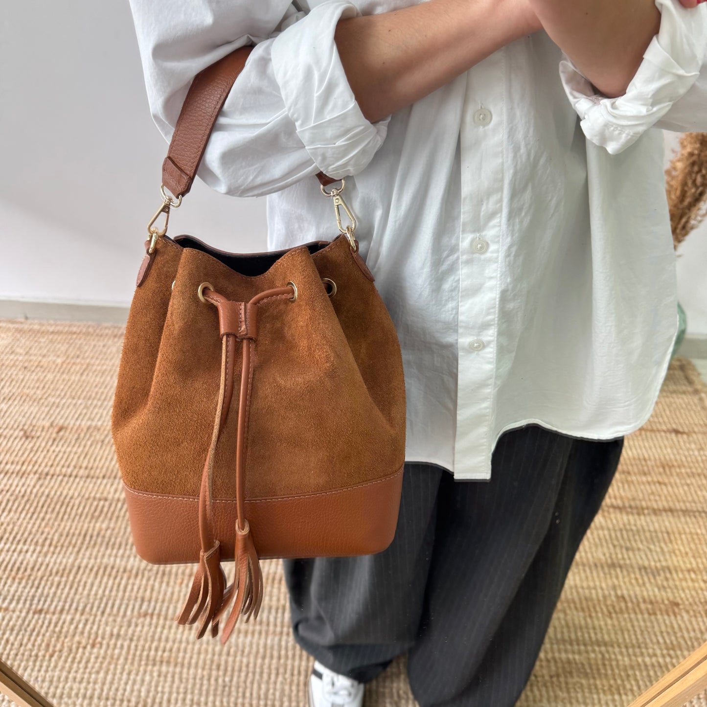 Bolso bucket serraje y piel camel grande pompón iniciales bordadas