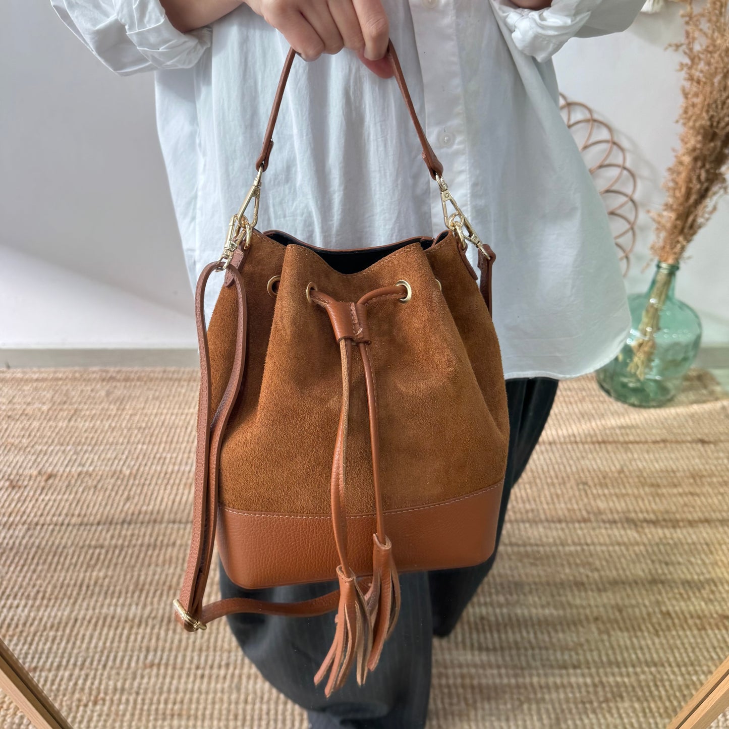 Bolso bucket serraje y piel camel grande pompón iniciales bordadas