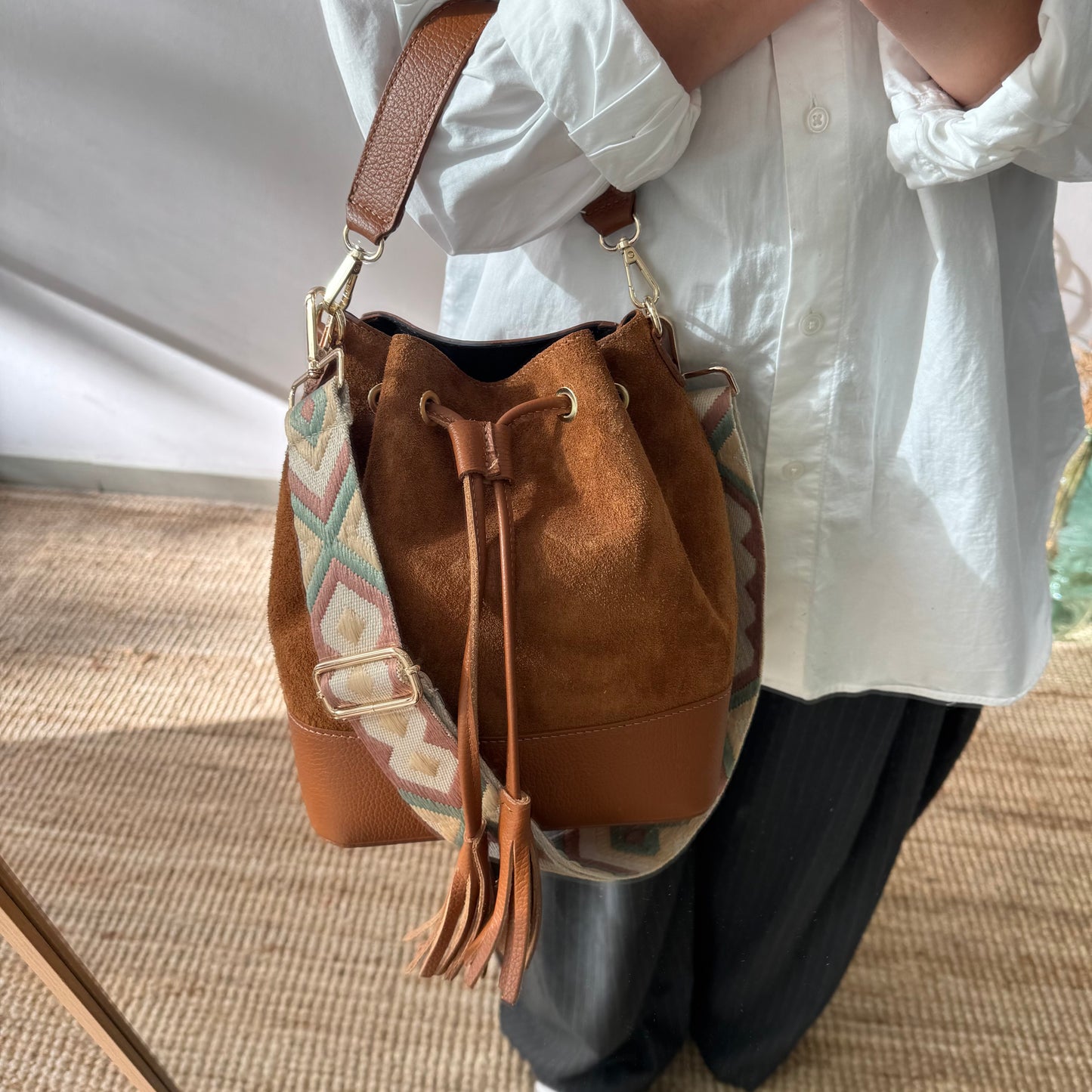 Bolso bucket serraje y piel camel grande pompón iniciales bordadas