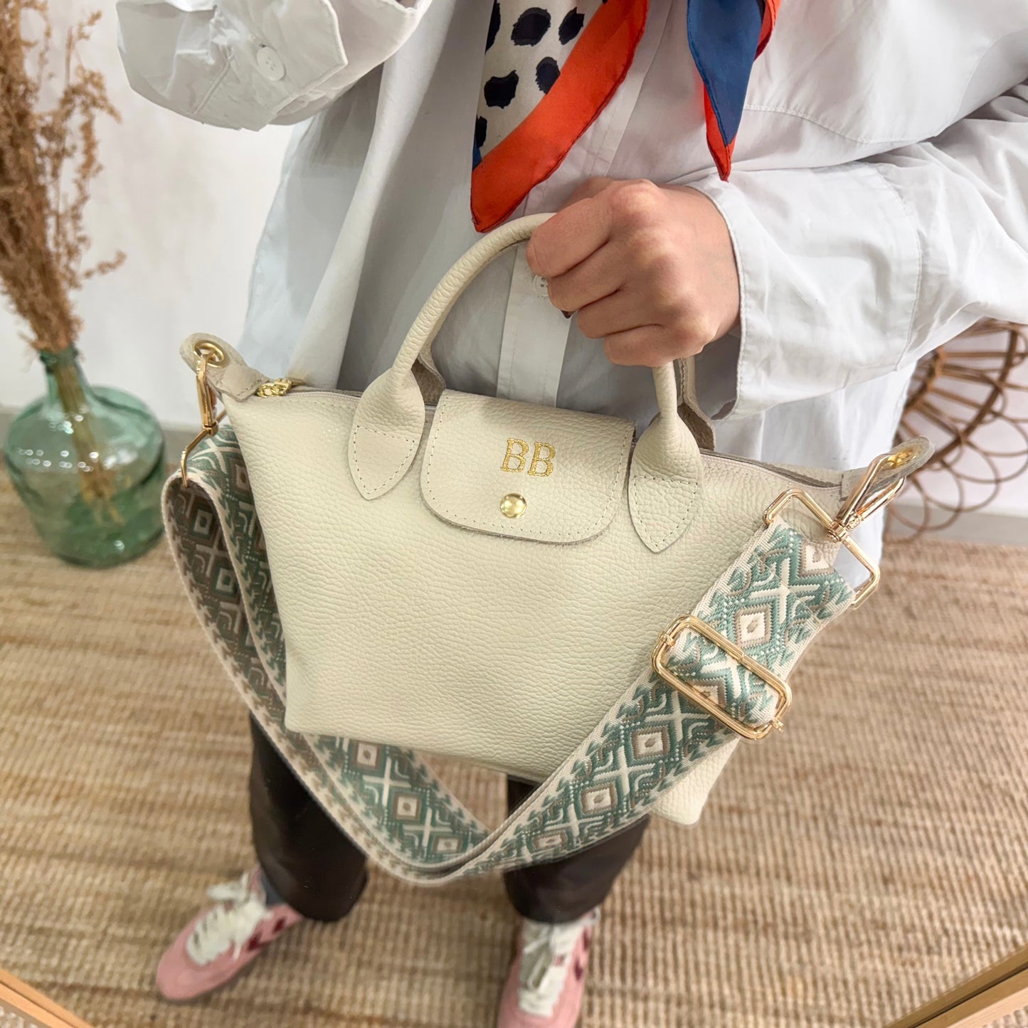 Bolso ovalado piel beige solapa iniciales bordadas