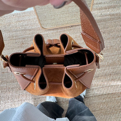 Bolso bucket combinado serraje y piel camel pompón iniciales bordadas