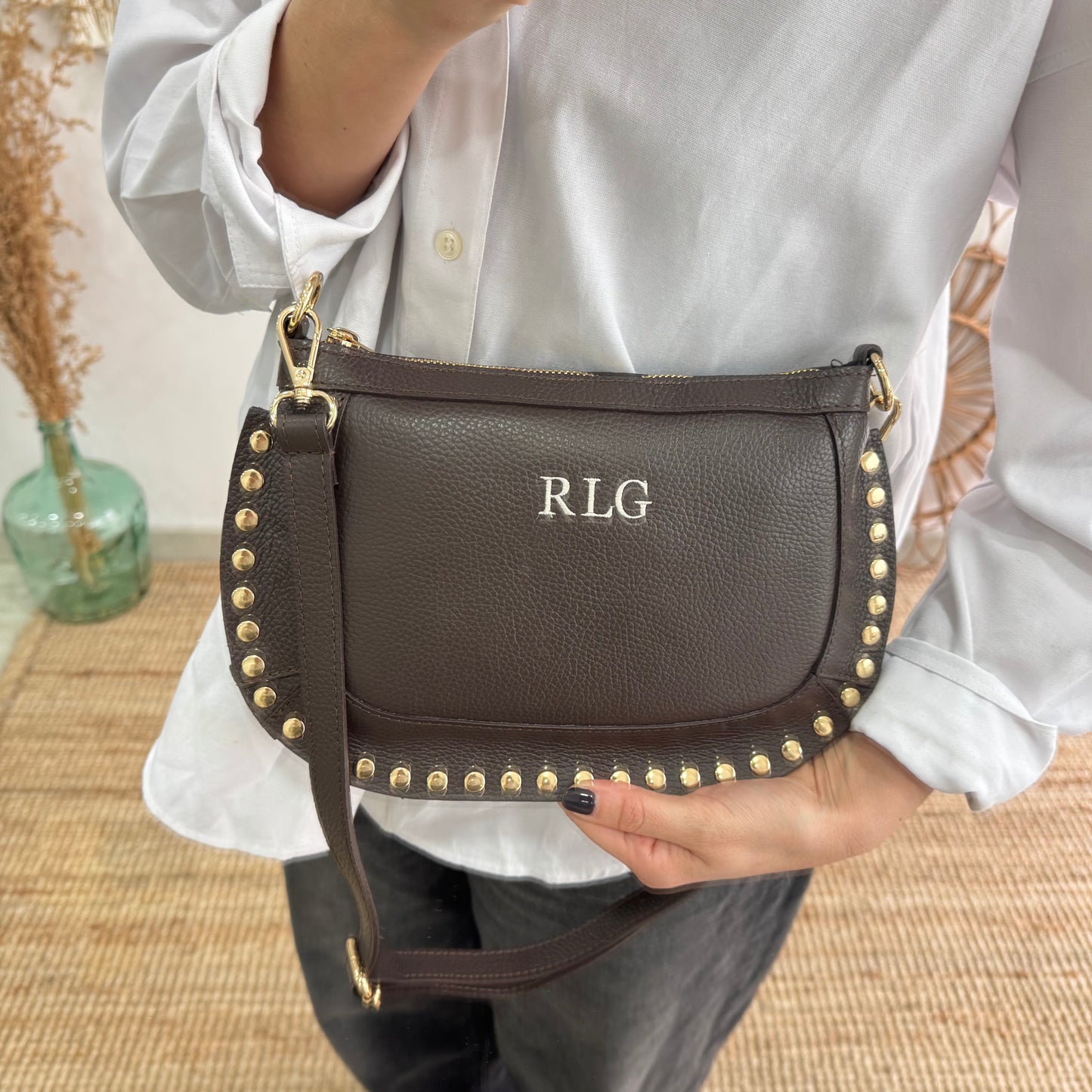 Bandolera ovalada piel tachuelas marrón iniciales bordadas