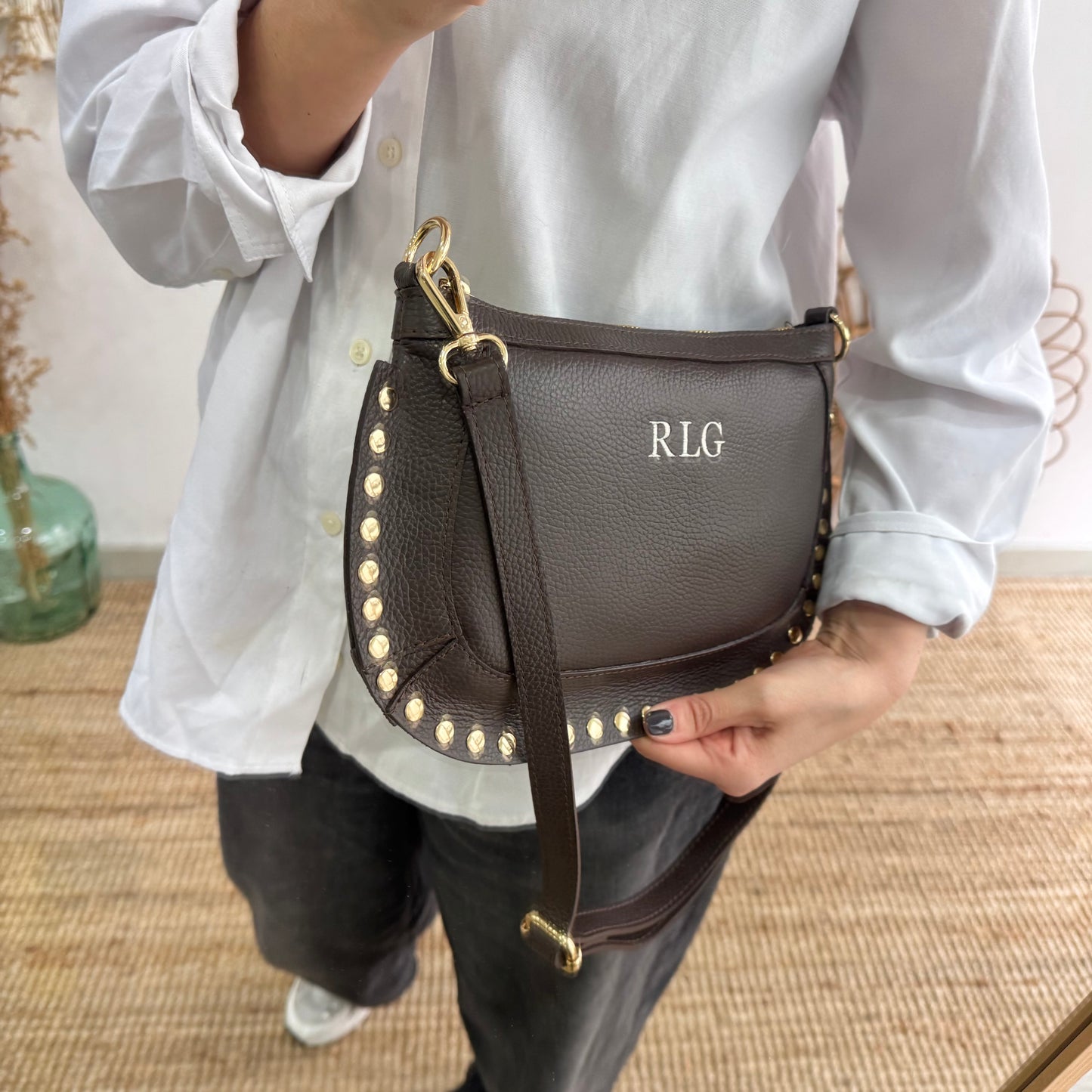 Bandolera ovalada piel tachuelas marrón iniciales bordadas