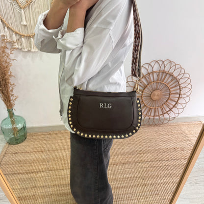 Bandolera ovalada piel tachuelas marrón iniciales bordadas