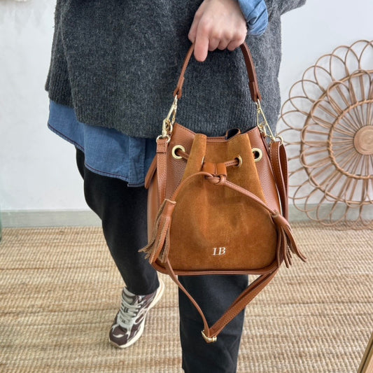 Bolso bucket combinado serraje y piel camel pompón iniciales bordadas