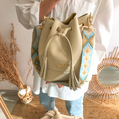Bolso bucket piel beige grande pompón iniciales bordadas