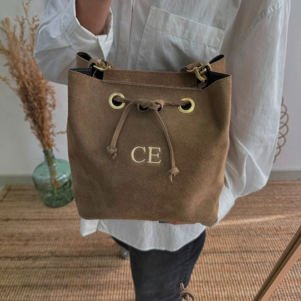 Bolso bucket serraje taupe arandelas herraje dorado iniciales bordadas