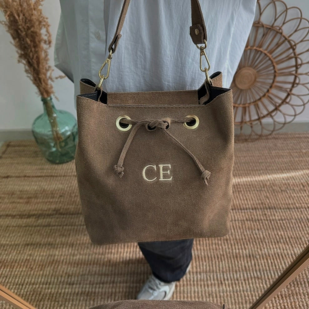 Bolso bucket serraje taupe arandelas herraje dorado iniciales bordadas