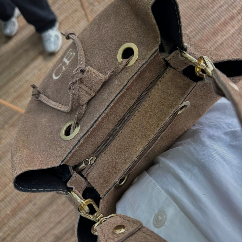 Bolso bucket serraje taupe arandelas herraje dorado iniciales bordadas