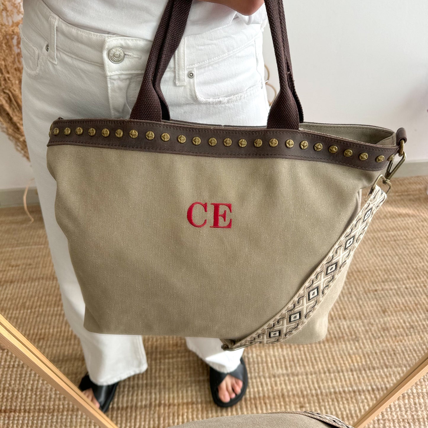 Bolso shopper loneta y piel taupe tachuelas iniciales bordadas con correa étnica