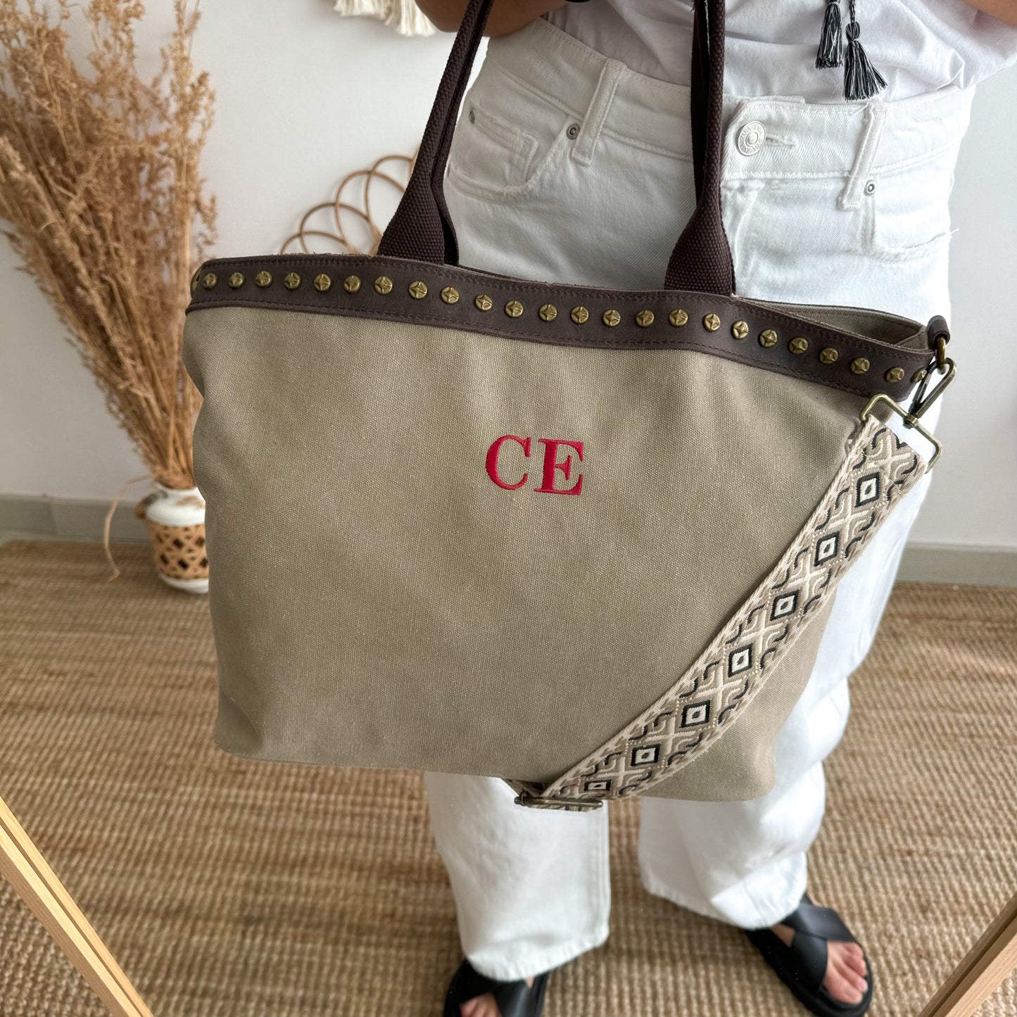 Bolso shopper loneta y piel taupe tachuelas iniciales bordadas con correa étnica