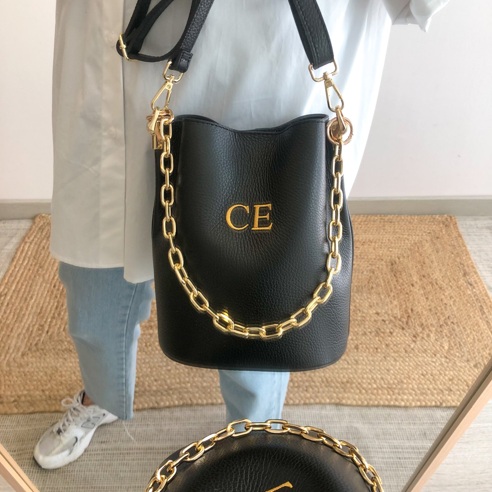 Bolso bucket piel negro cadena dorada iniciales bordadas